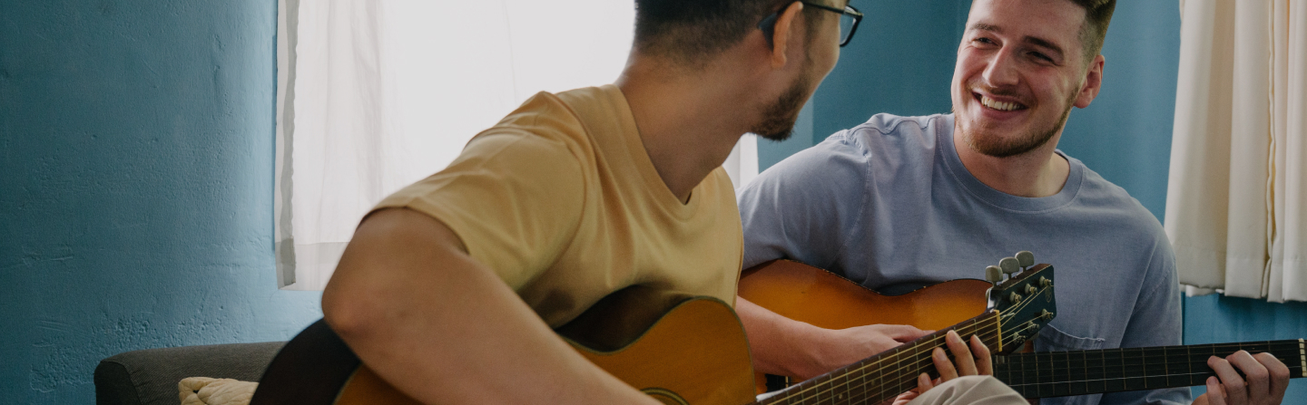 två män som spelar gitarr i en säng