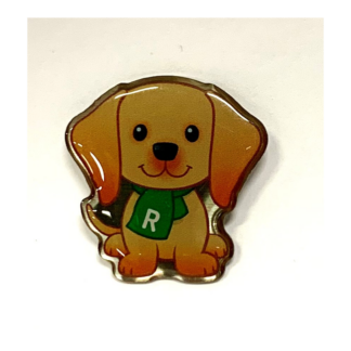 Bild på en glad hund med en elegant halsduk prydd med Reumatikerförbundets symbol.
